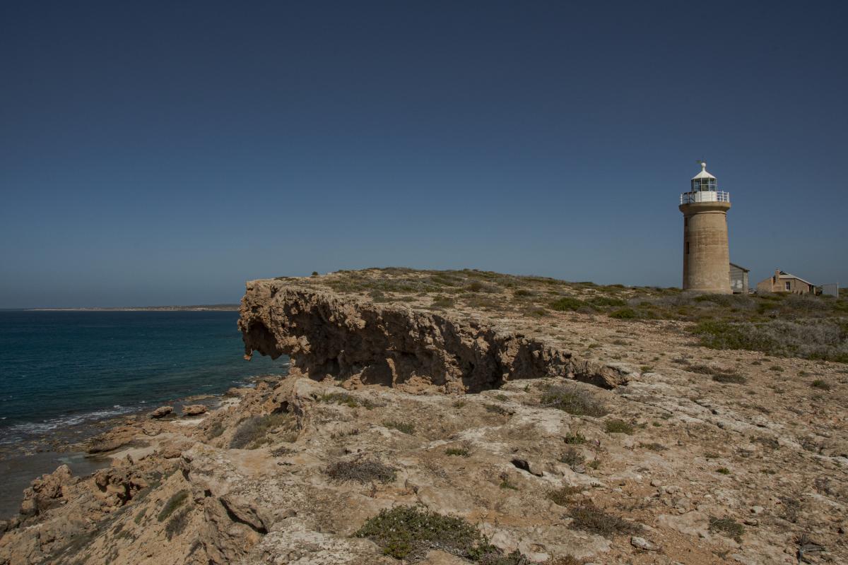 lighthouse and old buildings by the cliff edge at cape inscription