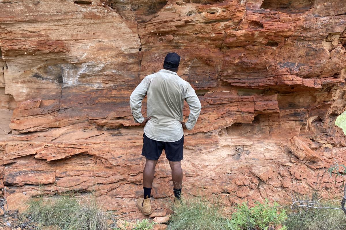 Ranger looking at artsite two on the trail