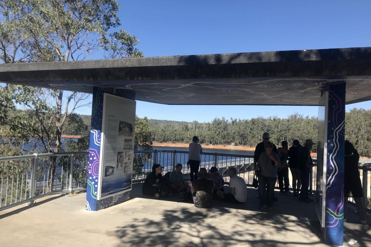 People sitting in the information shelter at Wellington Dam Lookout