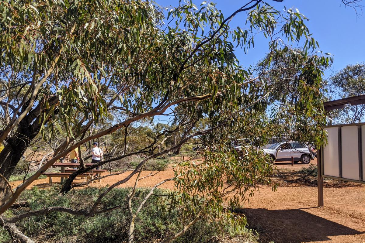 Picnic bench, parking area and sign at Miners