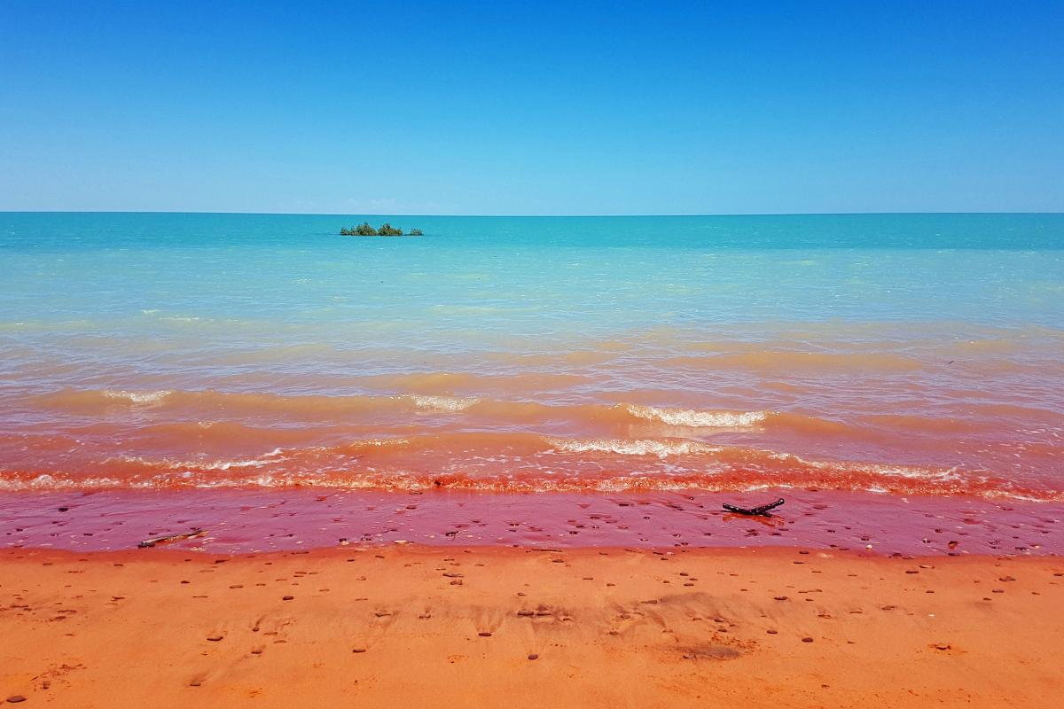 Bright blue waters with pindan red sandy beach.