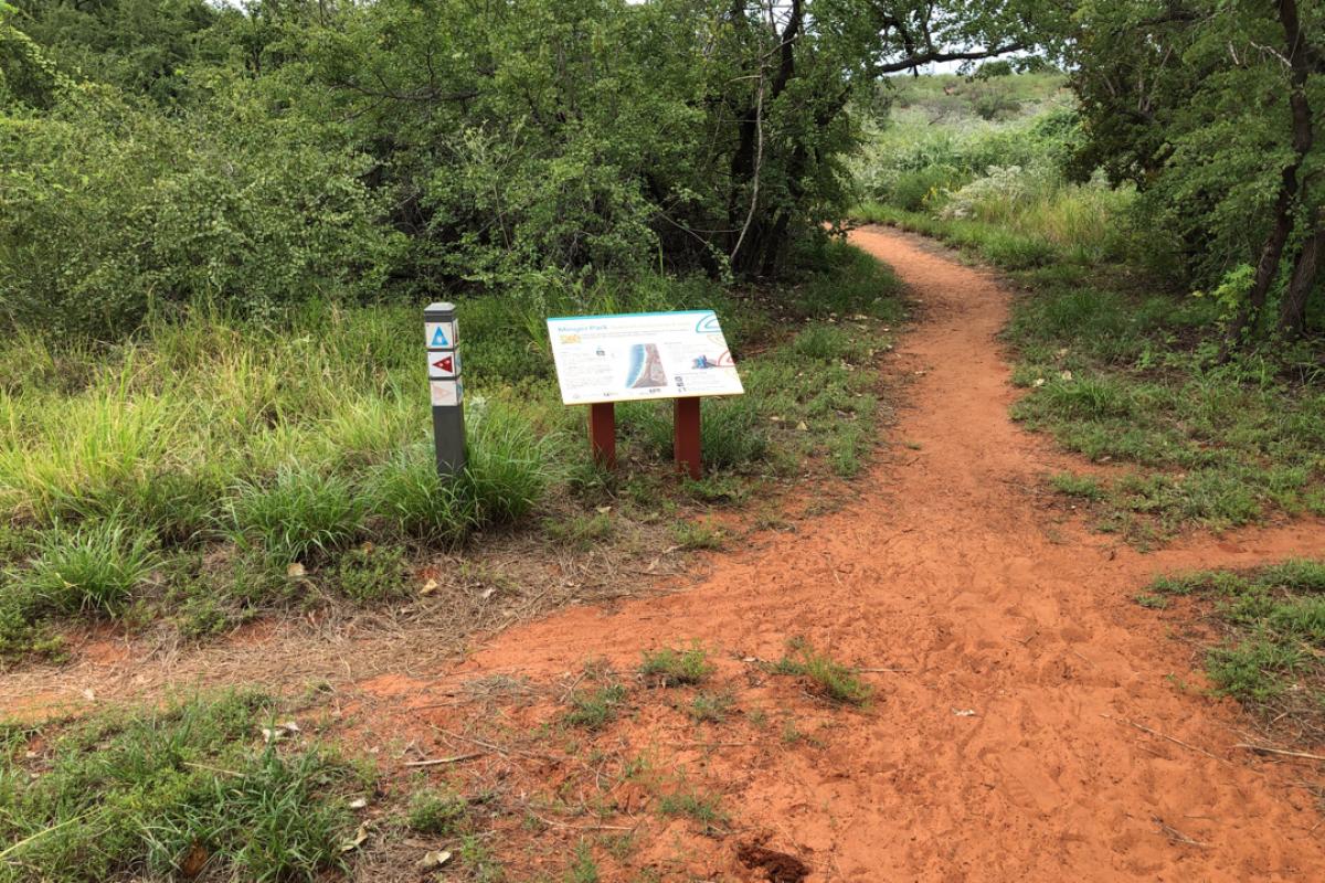 View of red dirt trails near a sign.