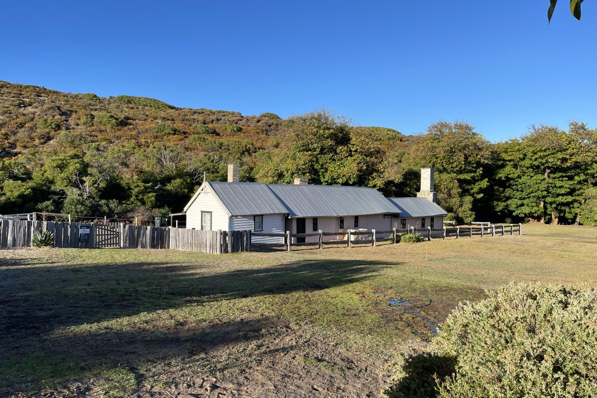 Historic house surrounded by old wooden fence.