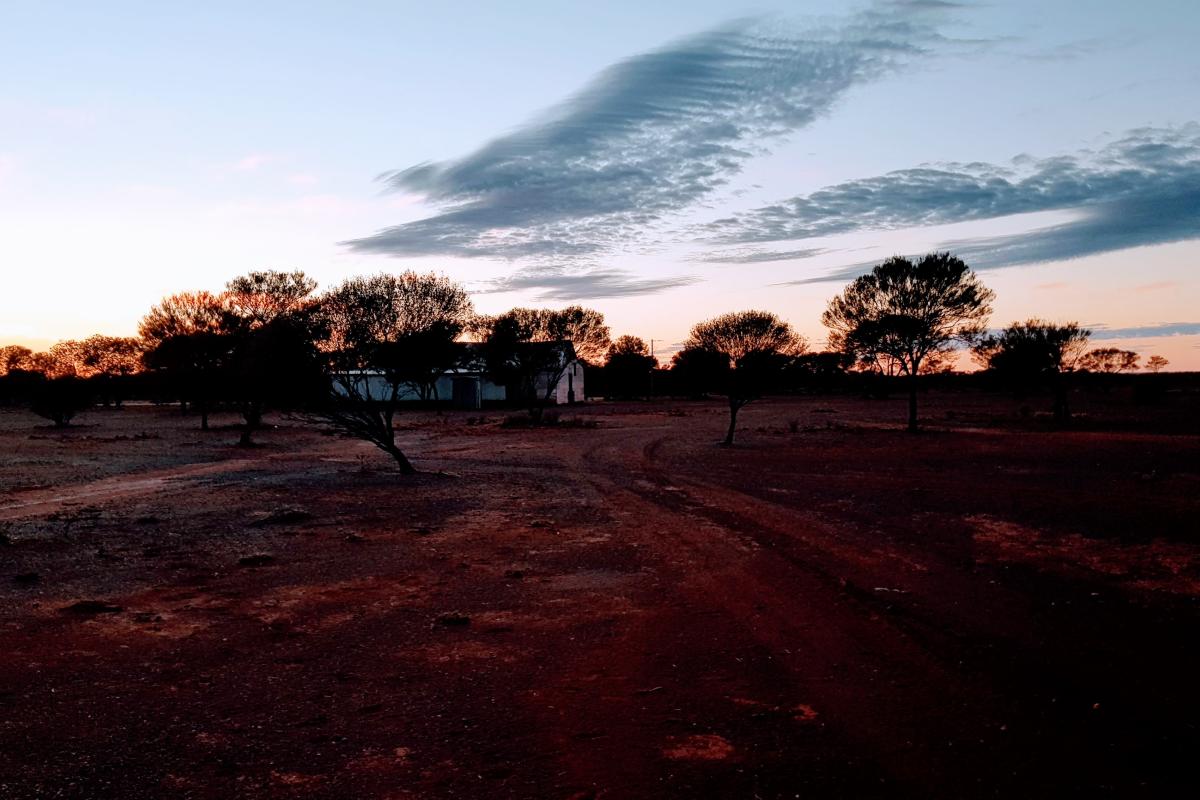 View of an older style farmhouse at sunset.