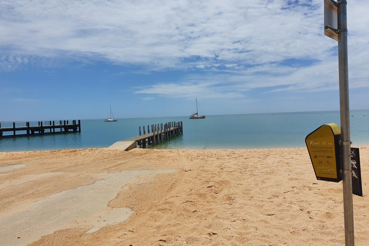 Monkey Mia Boat Ramp Small wooden jetty on a beach.