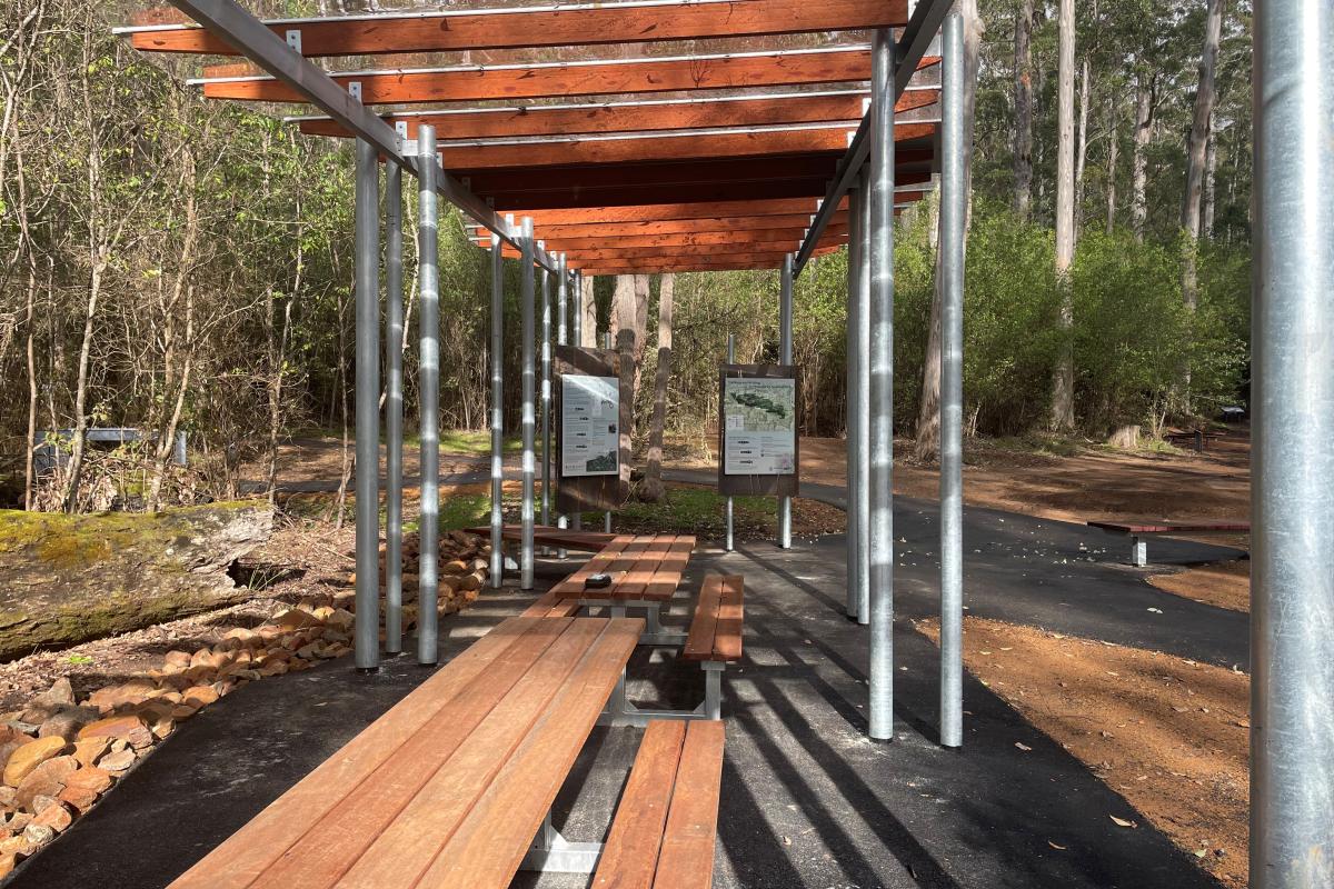 Wooden picnic tables and bench seats.