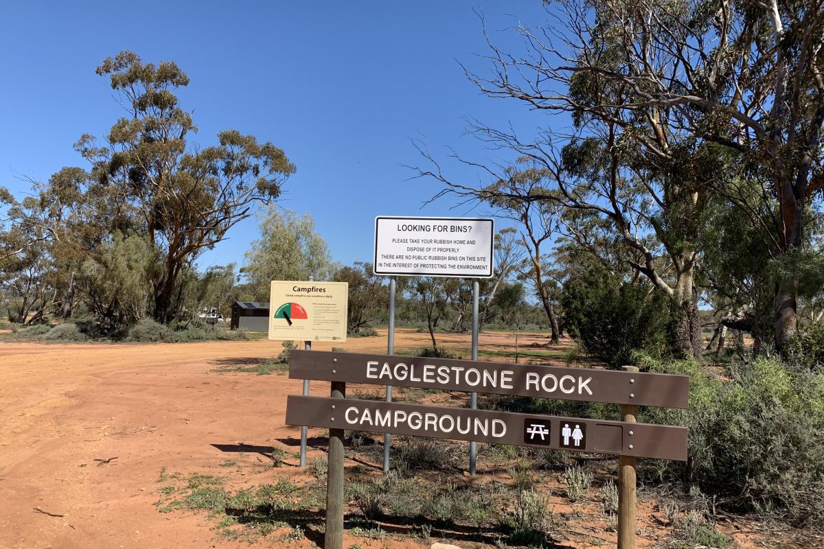 Sign and dirt road leading to campground. 