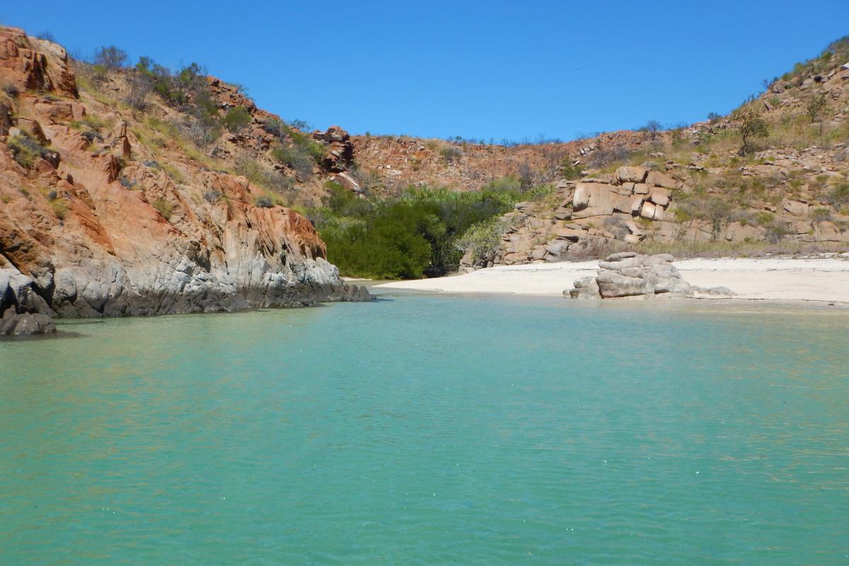 View from the ocean of small bay of clear green water. 