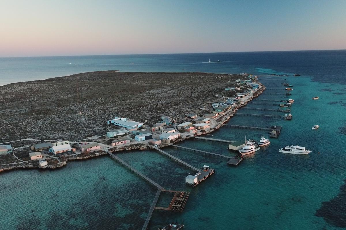 Houtman Abrolhos Islands National Park Aerial view of island with 8 jetties and a few boats floating nearby.