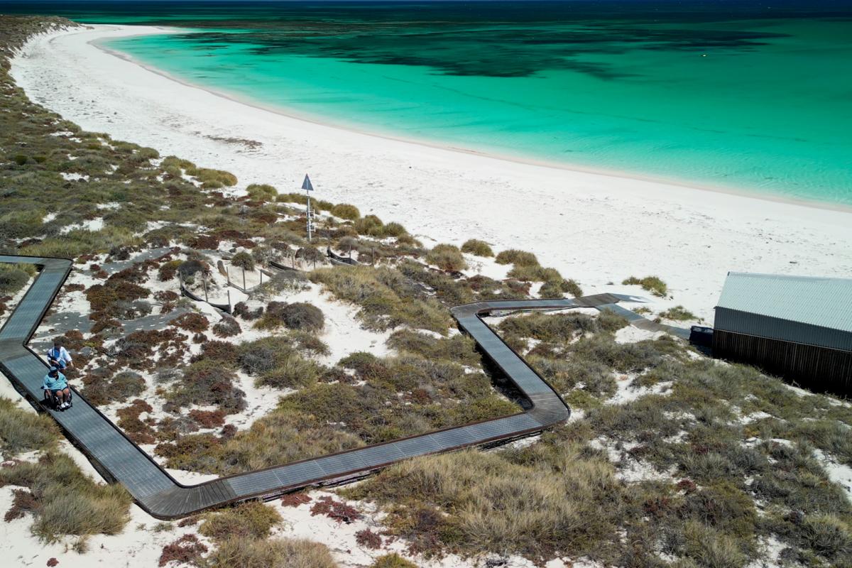Houtman Abrolhos Islands National Park Aerial view of boardwalk that leads down to shelter on a beach.
