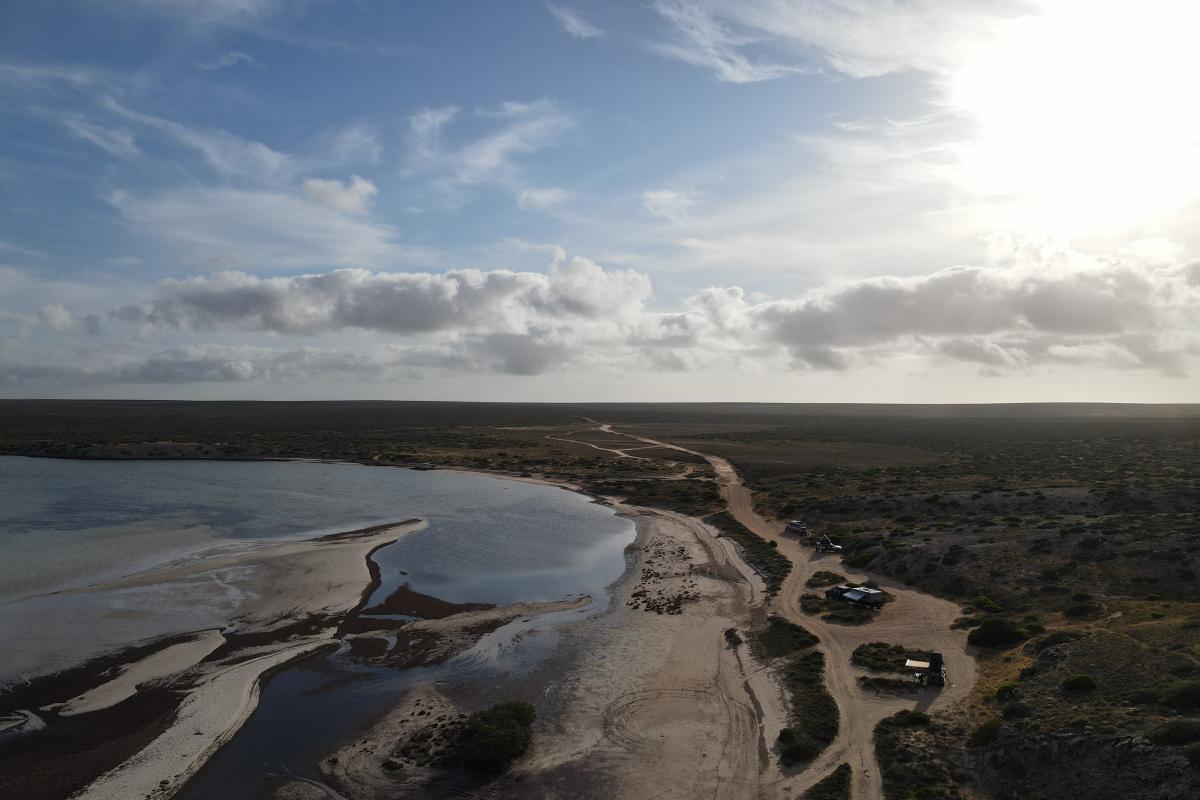 Aerial view of sandy campsites by the beach. 