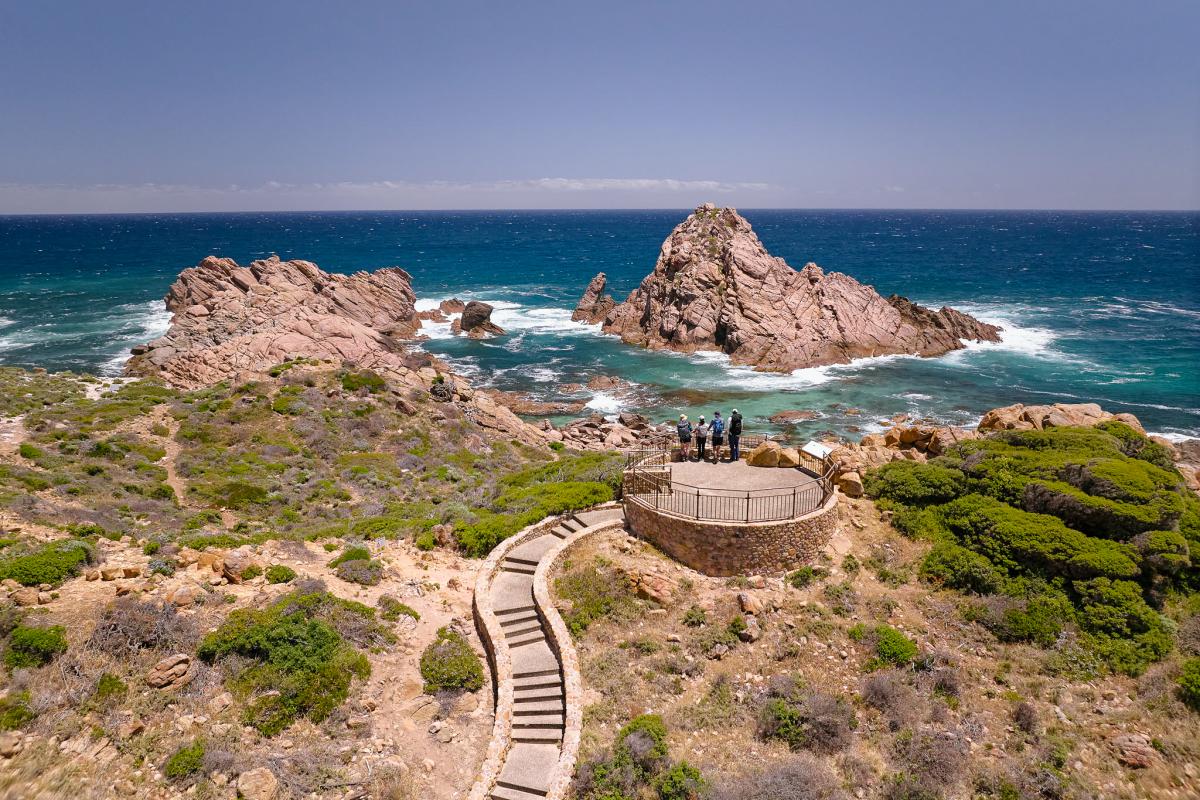 Hikers standing at lookout, overlooking Sugarloaf Rock. 