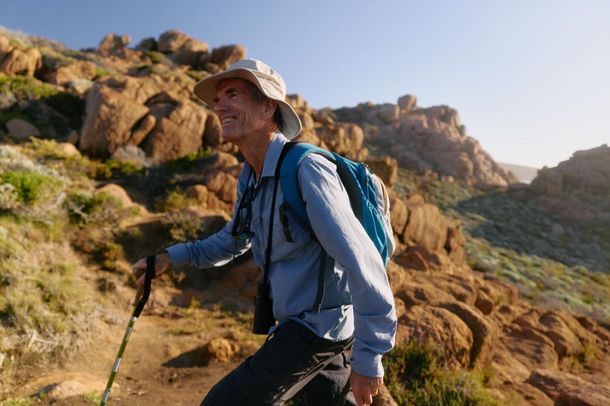Smiling hiker walking up rocky hill at Smiths Point