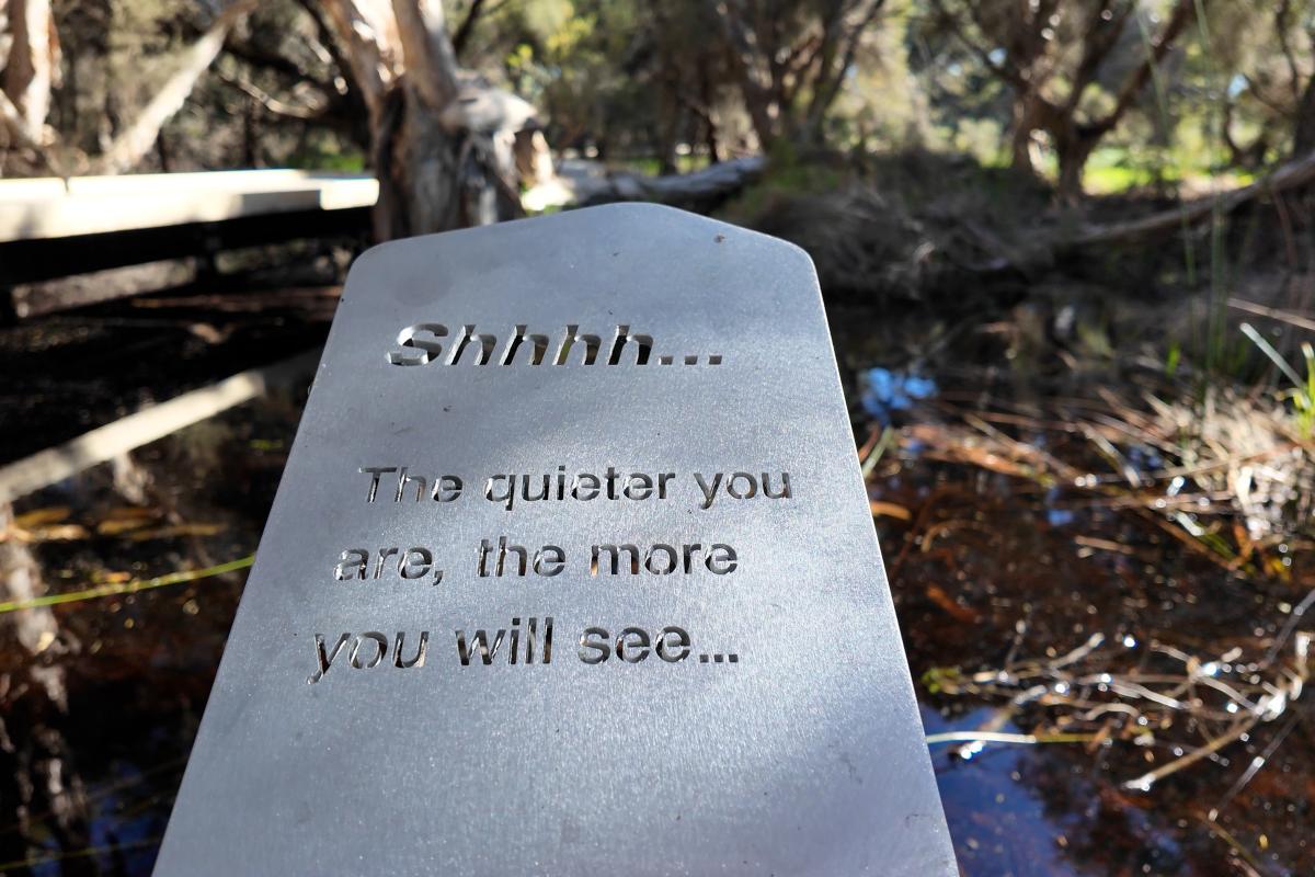 Close up of a sign that reads the quieter you are, the more you will see. 