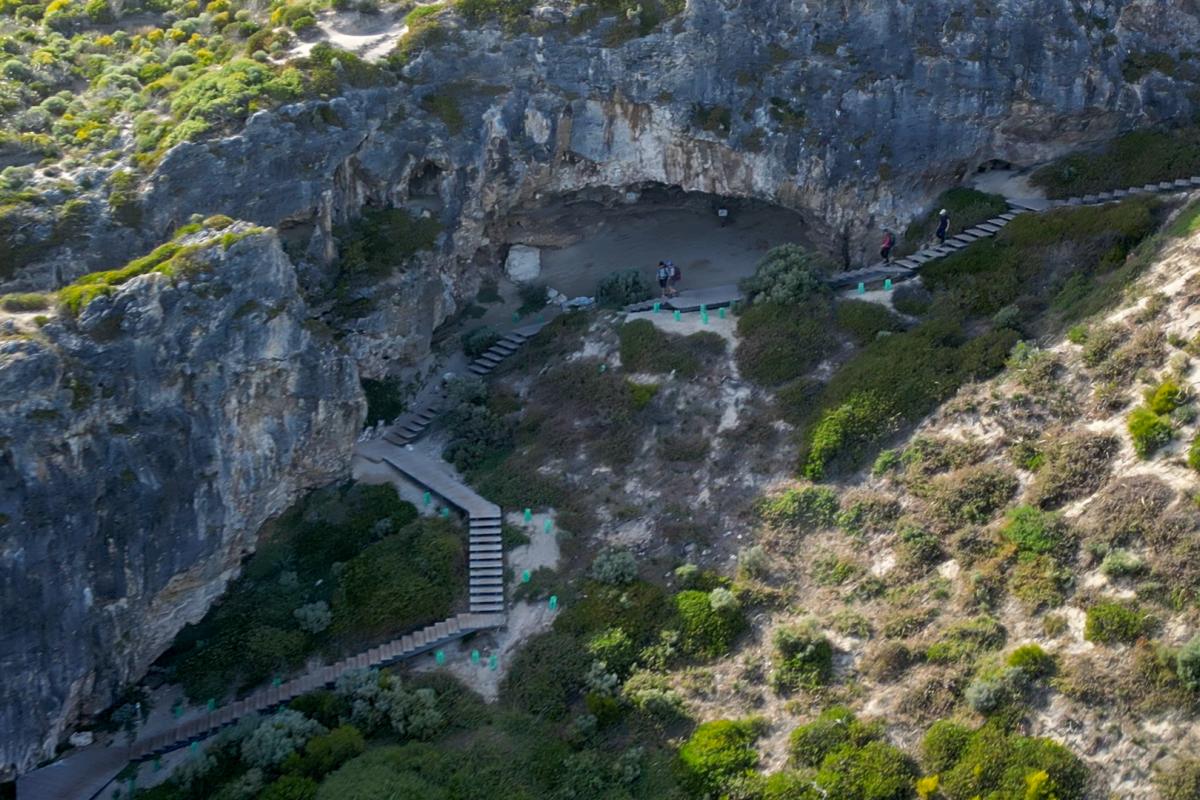 Aerial view of people walking down a long staircase down a hill. 