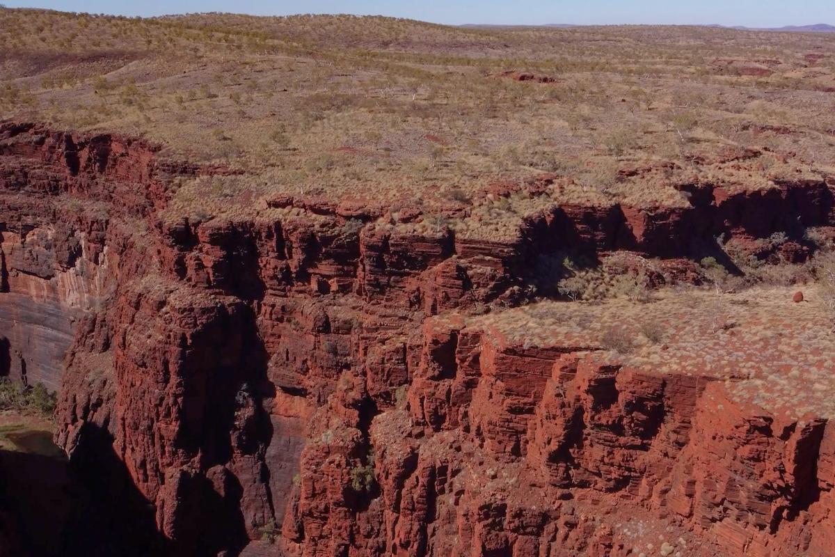 Aerial view of red dirt layered gorge. 