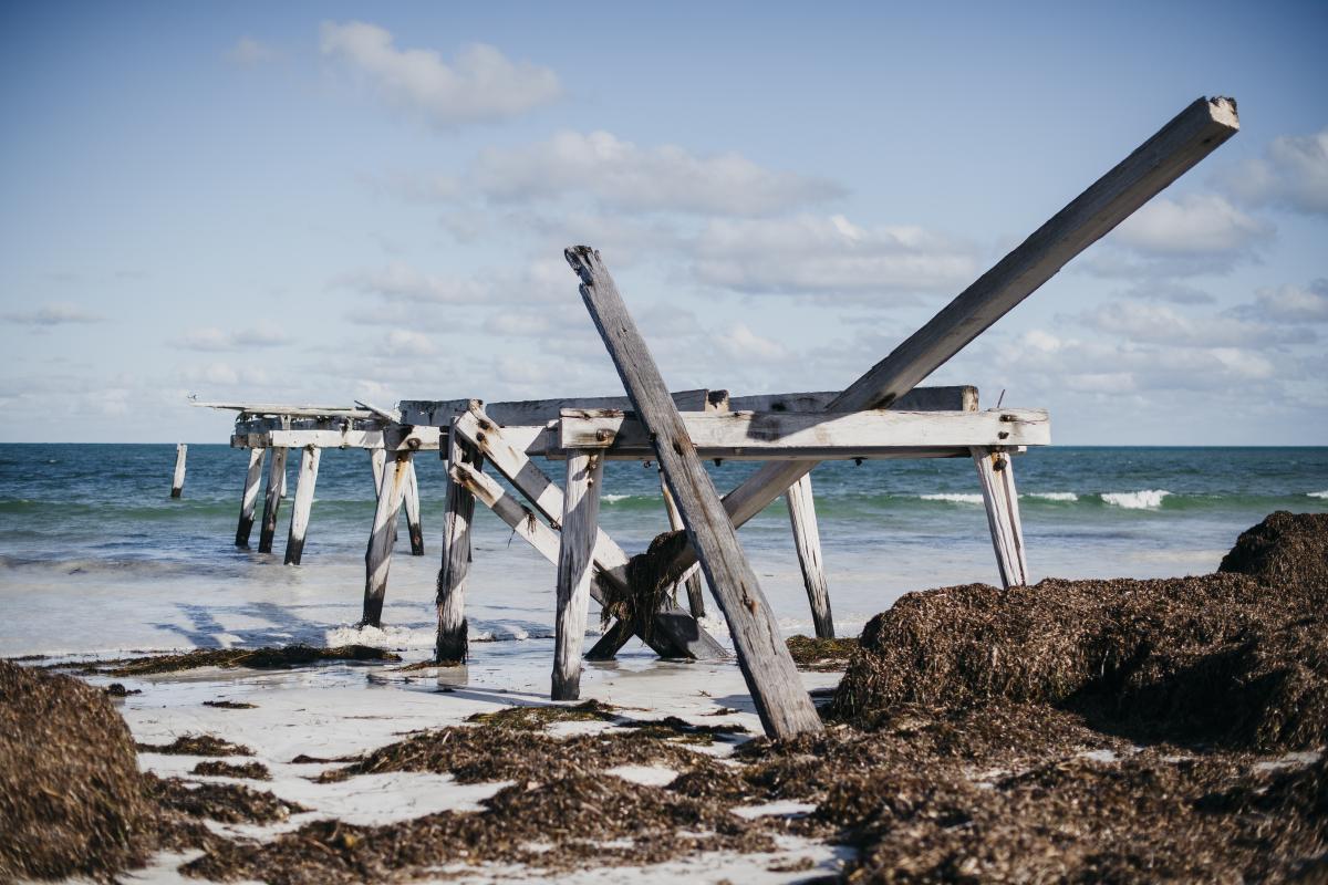 Wood jetty in ruins on a beach. 